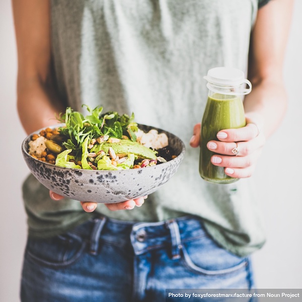 Nutrition and cancer - Woman with veggie bowl and green smoothie