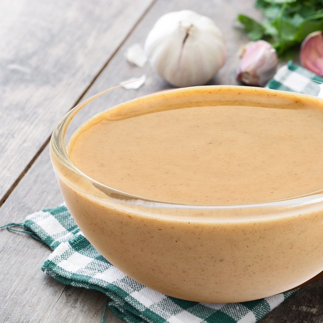 Bowl of sunflower sauce on a grey wood table