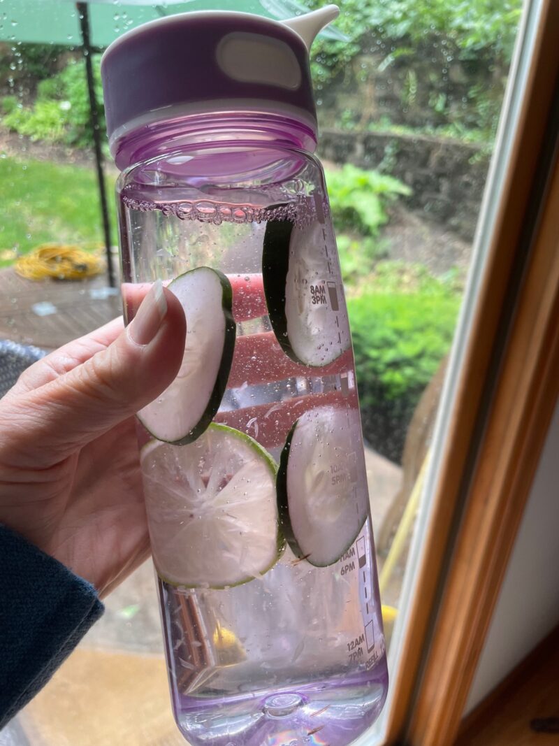 Purple water bottle with cucumbers and lime